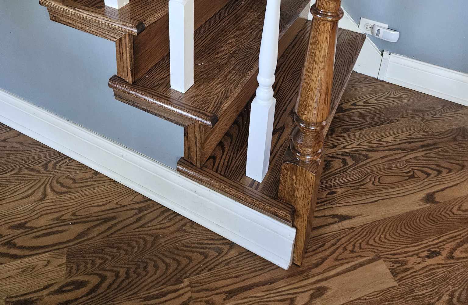 hardwood floor with matching stained staircase